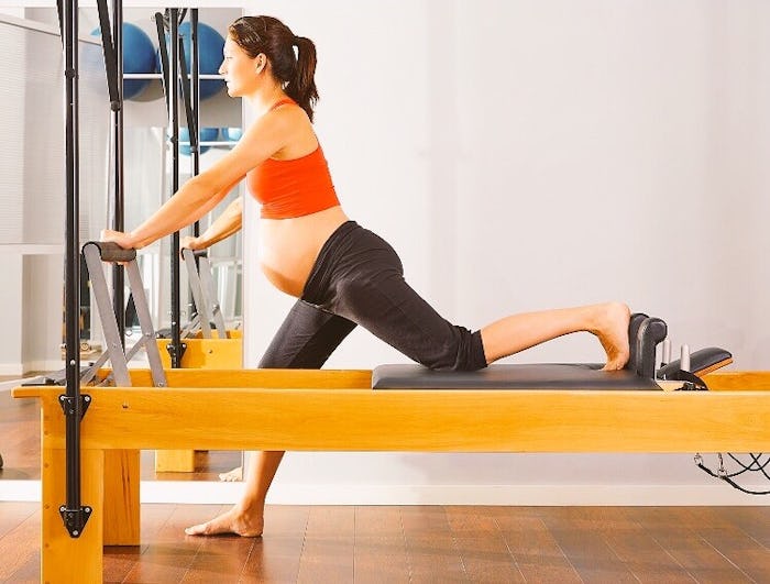 Pregnant woman doing reformer pilates
