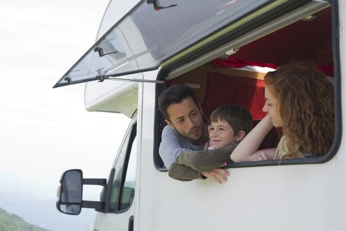 A father driving his kids to school in an RV