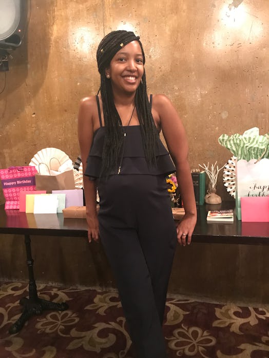 A black woman posing for a picture in front of a lot of gifts in a restaurant