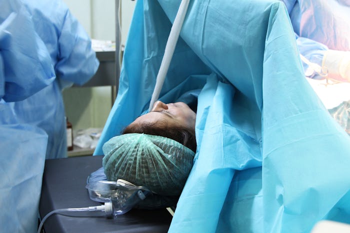 woman getting a c-section on a table in a hospital