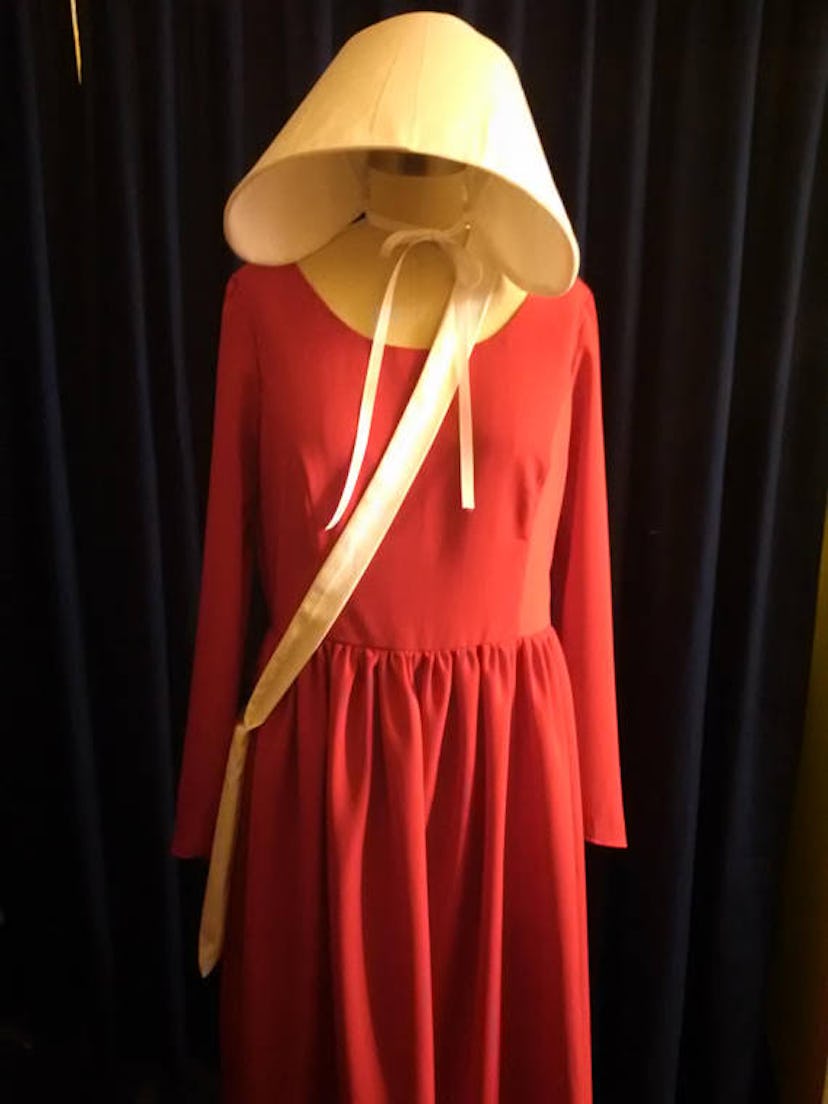 A long-handled white tote bag, red dress and the white bonnet 