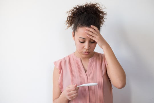woman looking at pregnancy test