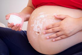 A pregnant woman using VIcks to get rid of stretch marks