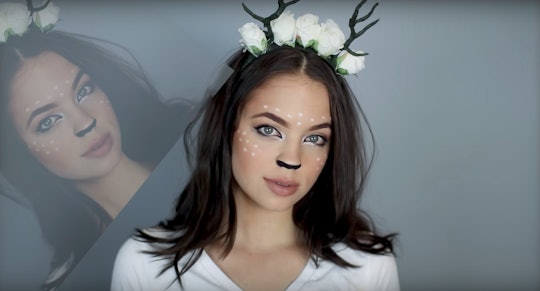 A girl with deer Halloween makeup, a white dress and a floral crown with deer antlers 