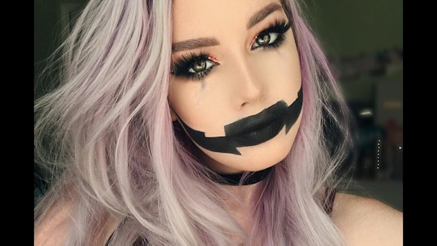A blonde girl with cute, yet creepy Jack-O'-Lantern makeup look ready for the Halloween