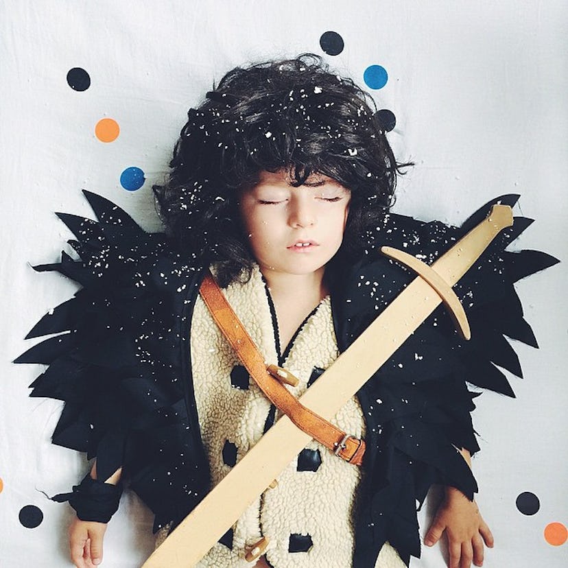 A kid wearing the Game of Thrones outfit for the Halloween taking a nap 