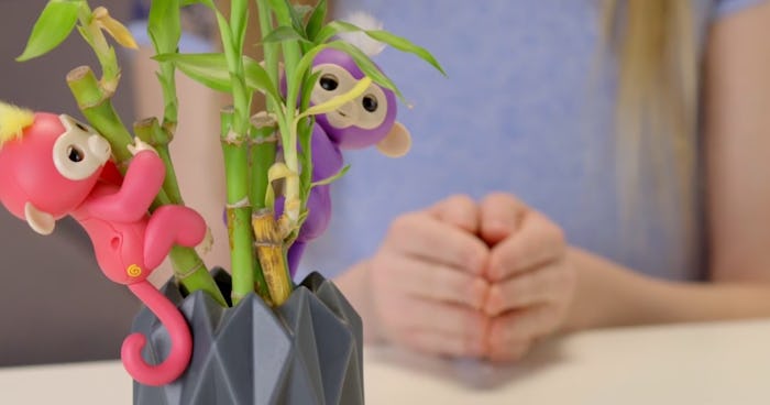 WowWee's Fingerlings Baby Monkeys on a Lucky Bamboo with a girl's hands in the background