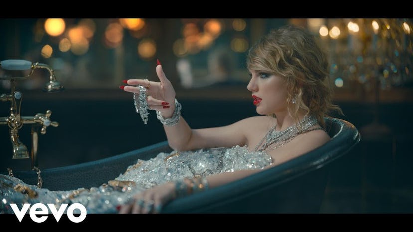 Taylor Swift lying in a bath tub in a music video