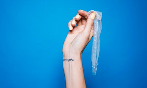 A hand holding a used condom