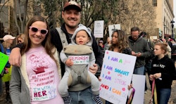 A mom, dad, and their baby at the Women's March