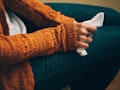 A woman in a mustard sweater holding a napkin on her lap, because she caught the flu