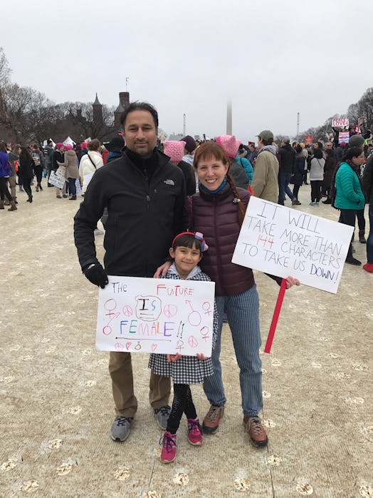 Kate and her husband and daughter at the the inaugural Women's March holding signs 