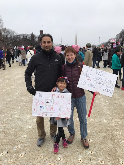 Kate and her husband and daughter at the the inaugural Women's March holding signs 