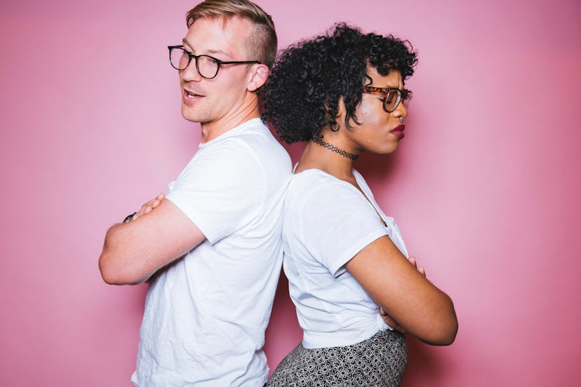 An angry-looking woman with an obsessive-compulsive personality standing back-to-back with a man 