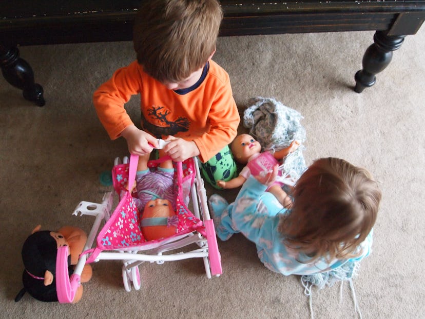 Gemma Hartley’s toddler boy and girl playing with dolls inside.