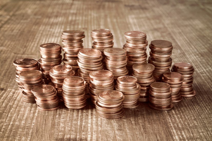 Multiple stacks of coins on a wooden table