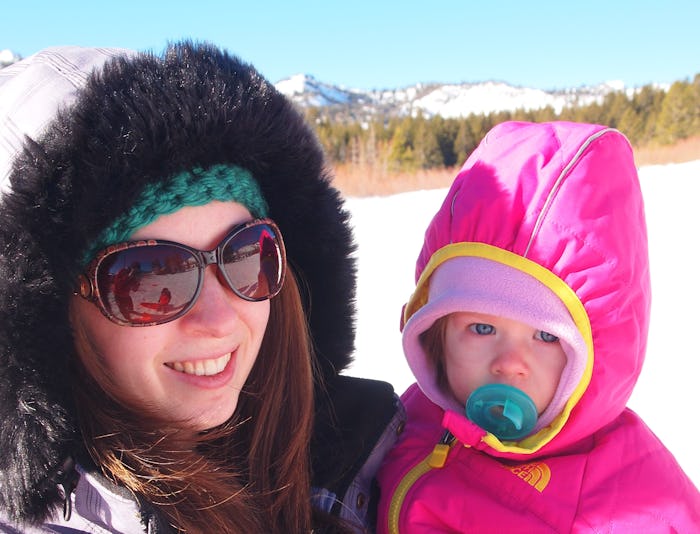 A mother who tried parenting like the Swedish, holding her kid, both in winter clothing