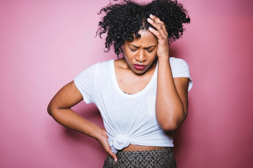 Depressed woman, looking down and holding her head