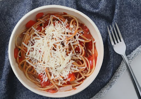 Spaghetti with parmesan served on a plate with a fork