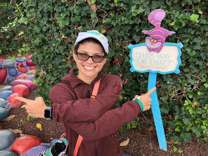 A woman posing next to a "this way or that?" sign