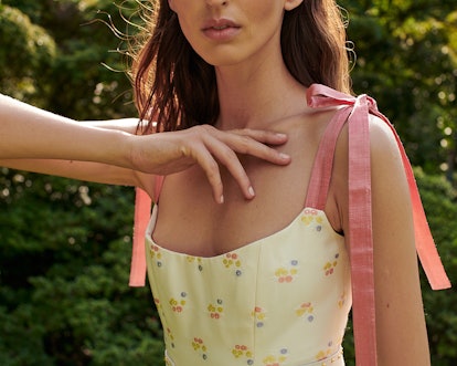 A girl wearing the Markarian peach-colored dress with flower details on it.