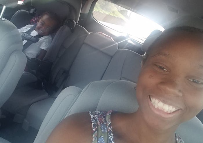 Rochaun Meadows-Fernandez smiling while taking a car selfie with her son sitting in a car seat at th...