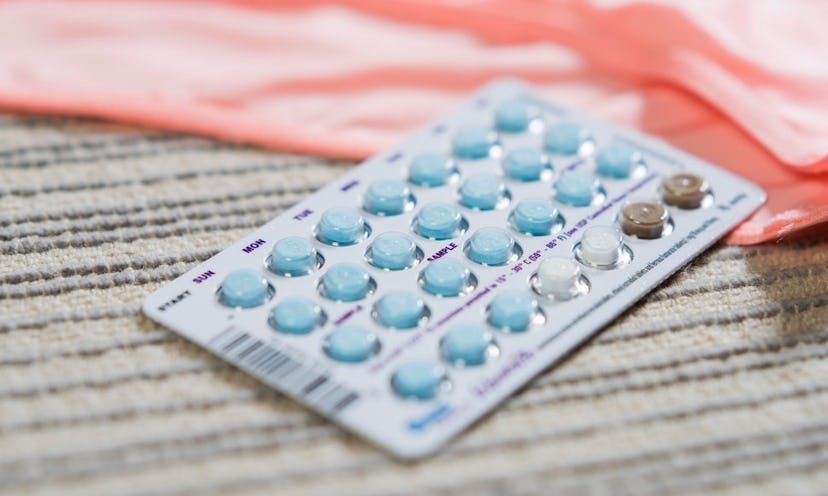 Birth control pills on a beige surface