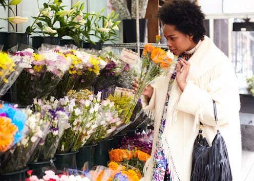 A woman sniffs flowers, remembering her past. Here's how nostalgia can change your brain, according ...
