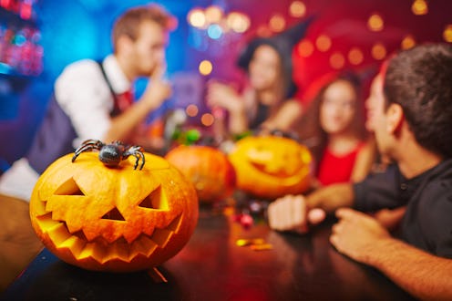 Adults in costume playing Halloween Games at the bar, with Halloween decorations around them