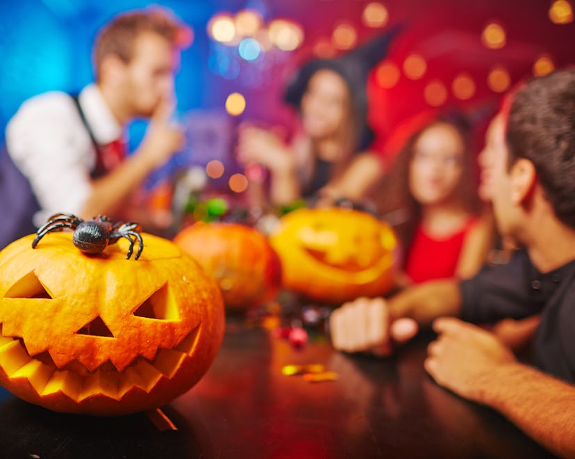 Adults in costume playing Halloween Games at the bar, with Halloween decorations around them