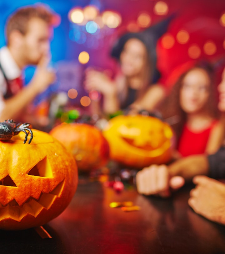 Adults in costume playing Halloween Games at the bar, with Halloween decorations around them