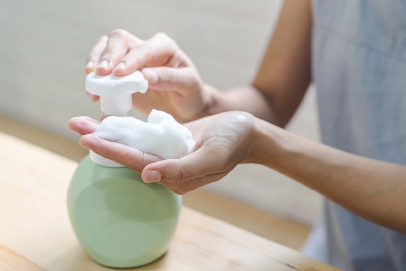 A girl pouring a lot of hand sanitizer on her hands