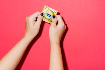 A girl holding a yellow Durex package of condoms