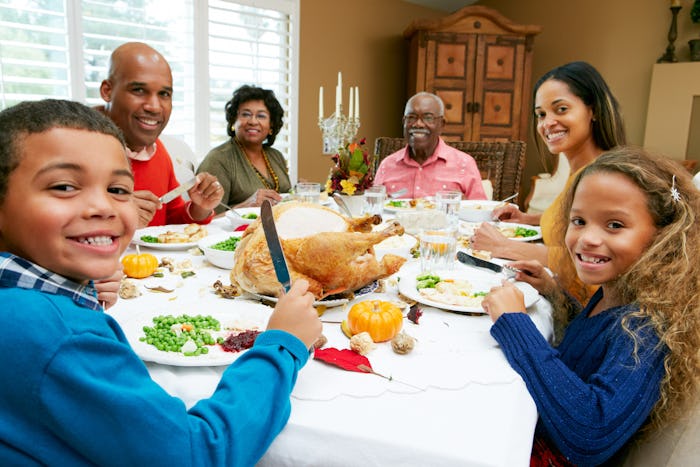 family sitting down at Thanksgiving dinner table