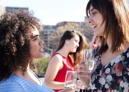 Two female friends enjoying a conversation with a glass of champagne 