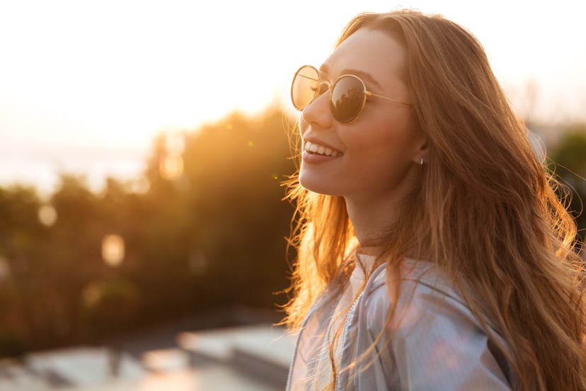A woman wearing sunglasses outdoors during October, in the golden hour of sunset. October 2021 bring...