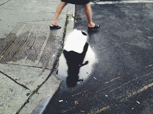 Depressing shadow in water of a walking woman