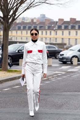 A woman wearing a white boxy jacket with red details and matching pants during Winter