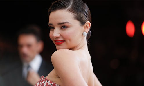 Miranda Kerr at a red carpet with her hair in a bun and in a strapless dress 