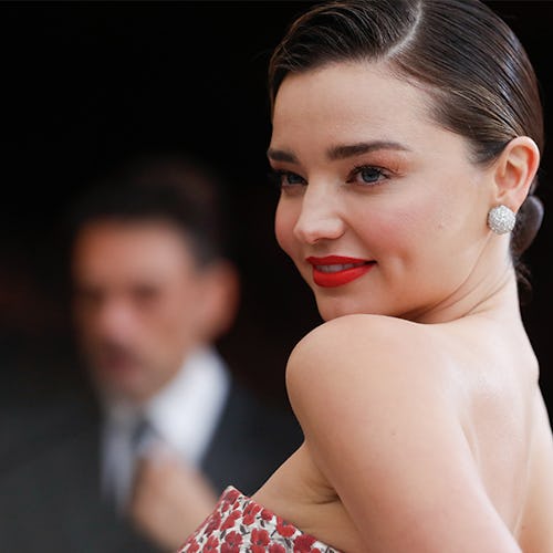 Miranda Kerr at a red carpet with her hair in a bun and in a strapless dress 