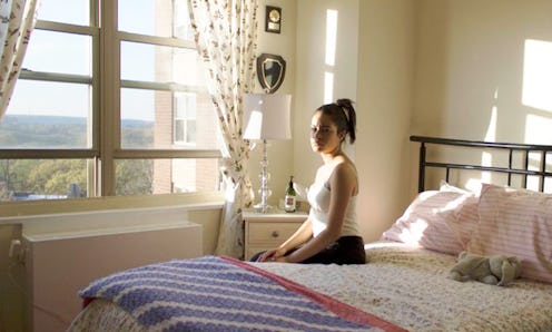 The Puerto Rican photographer, Angelina Ruiz sitting on a bed in front of a large window