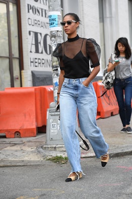 Street style photo featuring an outfit baggy jeans worn with a sheer black blouse that leans into th...