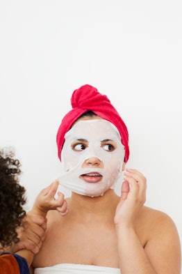 A woman waving a face mask on her face after shower