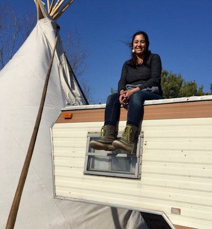 Christine Nobiss sitting on the roof of a travel van on Thanksgiving