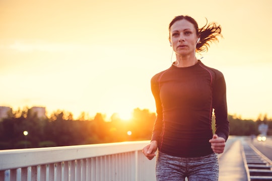 A young woman running over a bridge