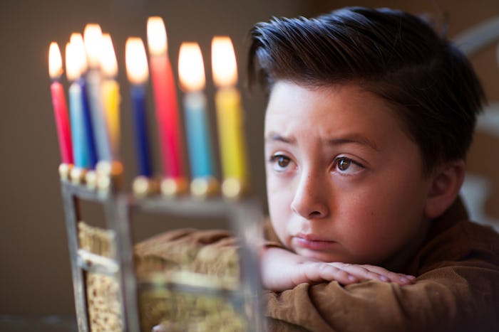 A boy looking at a menorah on Hanukkah