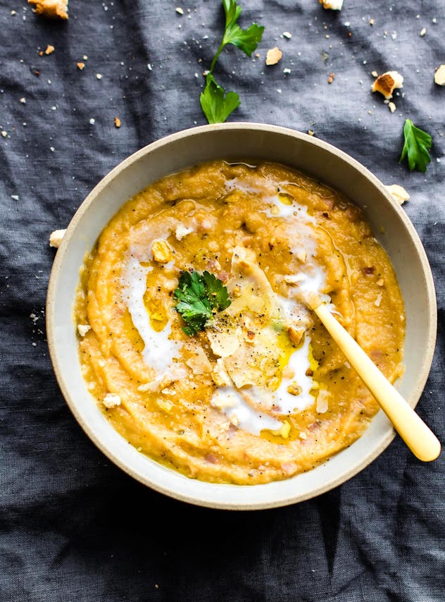 aerial shot of thick, yellow soup with a spoon in a bowl