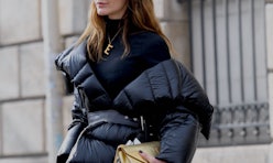 A woman wearing a black turtleneck and a black puffer winter jacket in New York