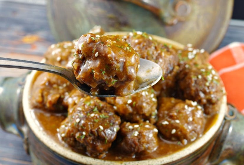 close up of glazed meatballs with sesame seeds sprinkled over top