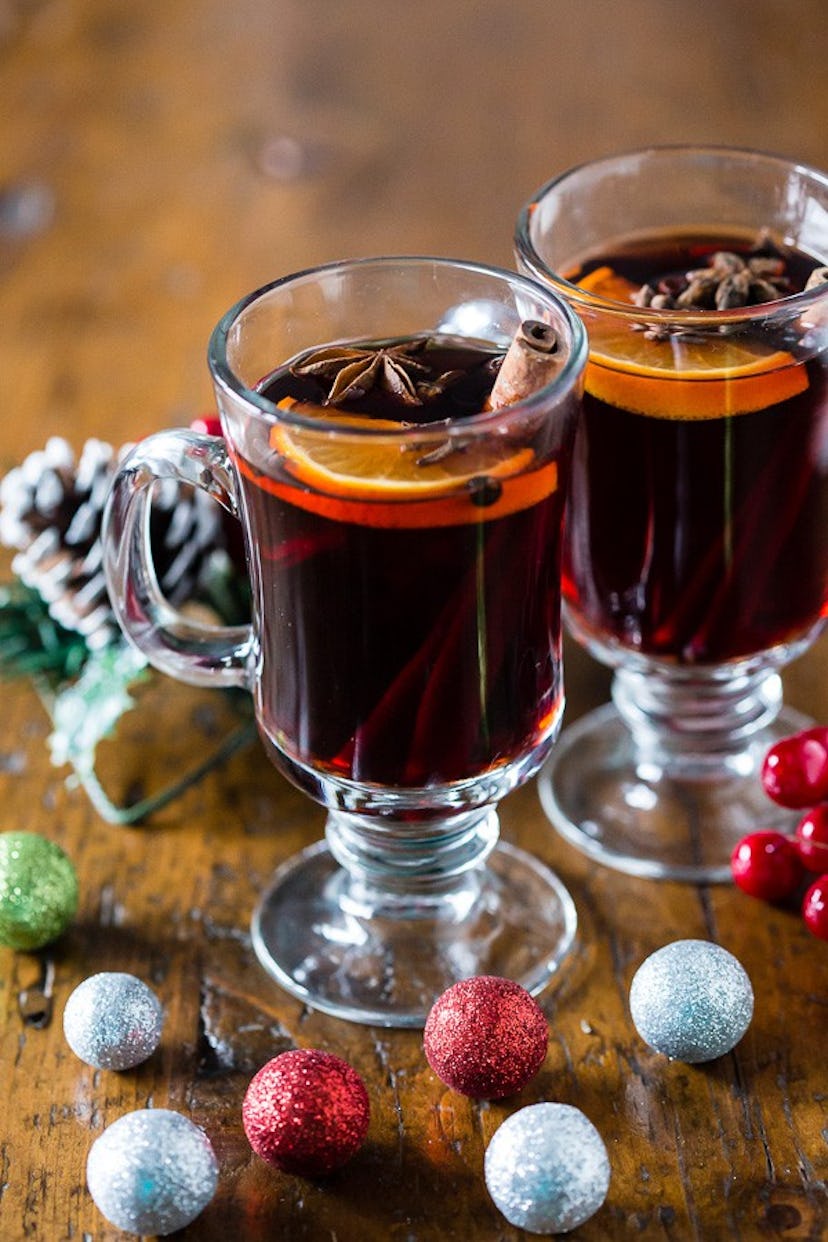 two glasses of mulled wine with cinnamon sticks and oranges inside
